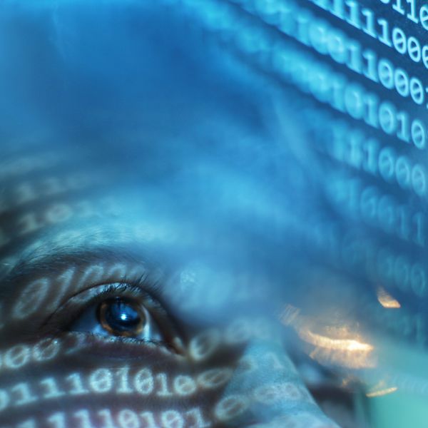 Person looking on blue screen lit with binary code