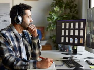 Businessman with headphones discussing during video conference.