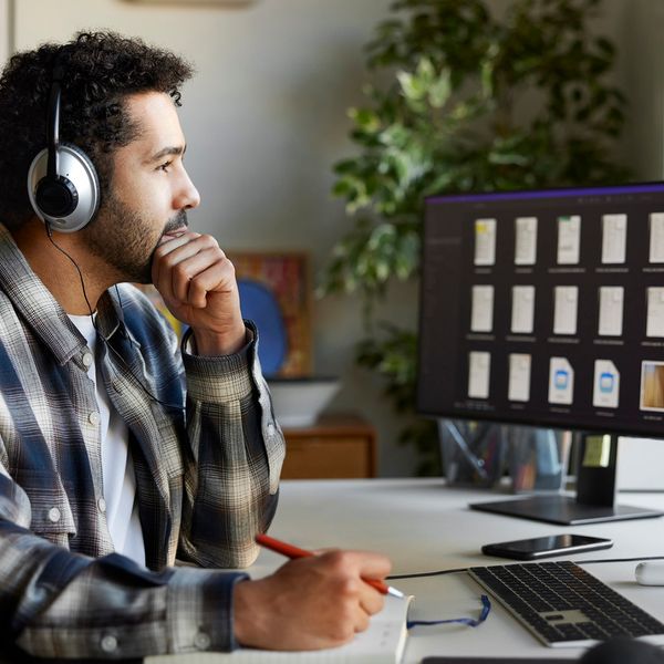 Businessman with headphones discussing during video conference.