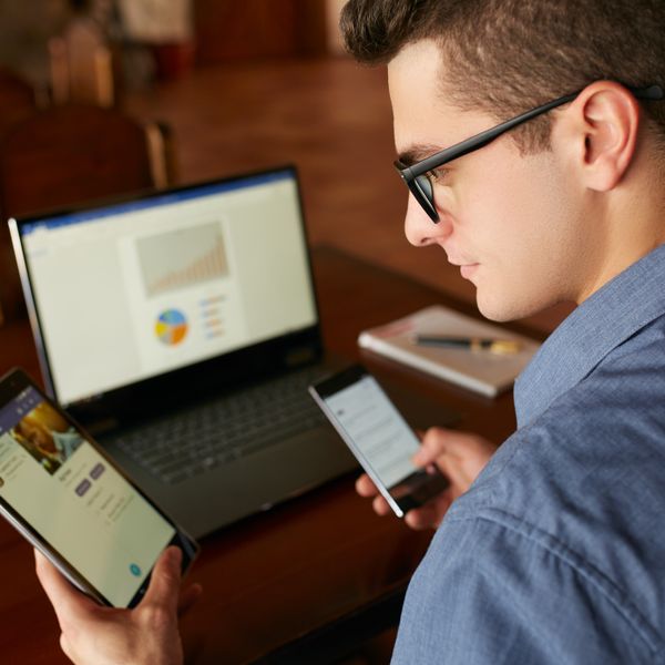 man using different devices tablet phone laptop
