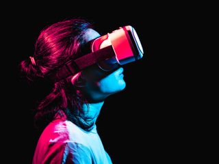 A woman using virtual reality headset in a dark room